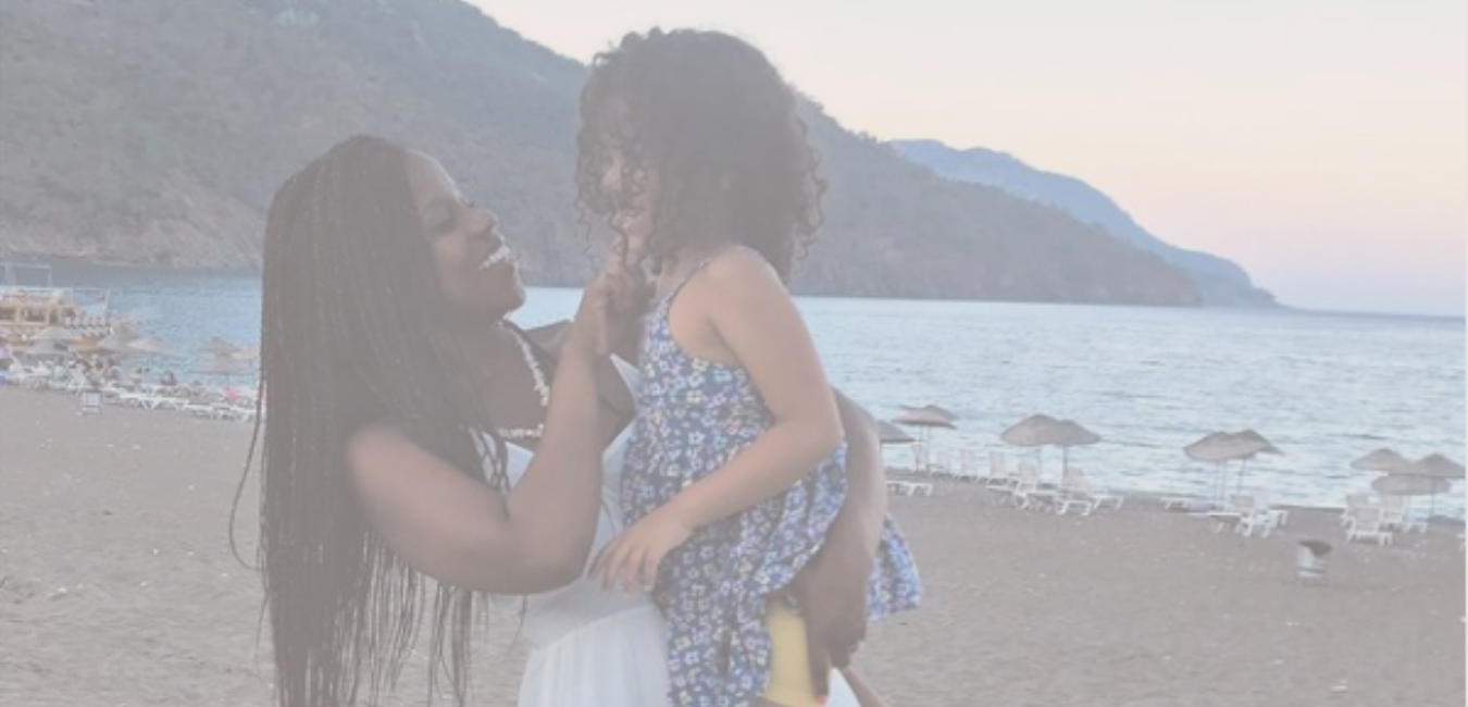 Adiya (a busy mom) holding her child on a beach